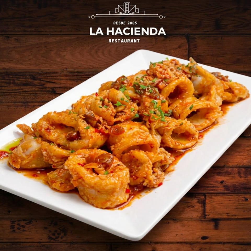 Plate of La Hacienda's fried calamari rings with a savory sauce and herbs.